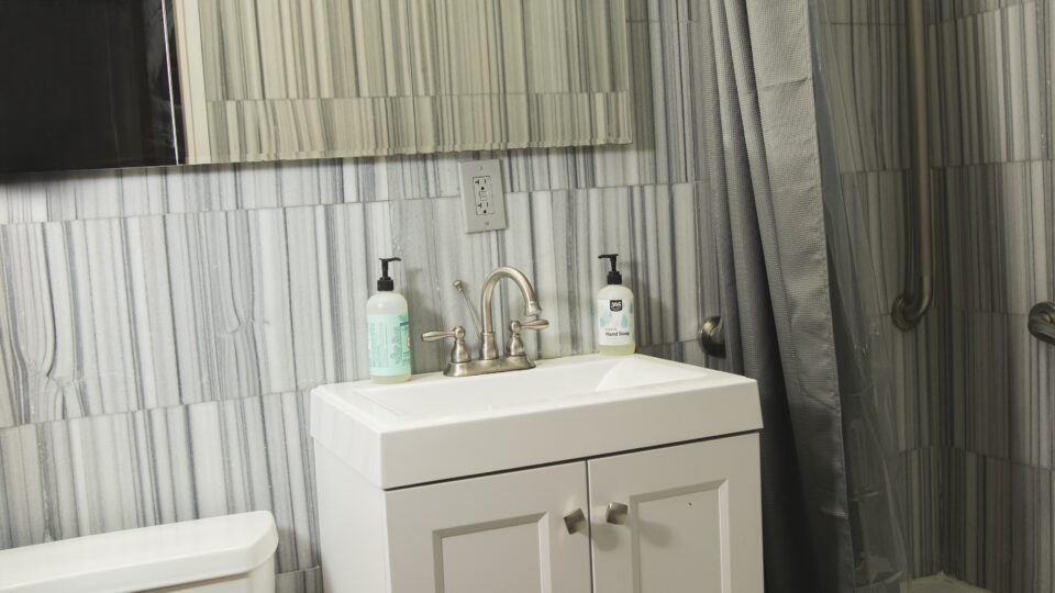 Et badeværelse i New York med toilet, håndvask og spejl.