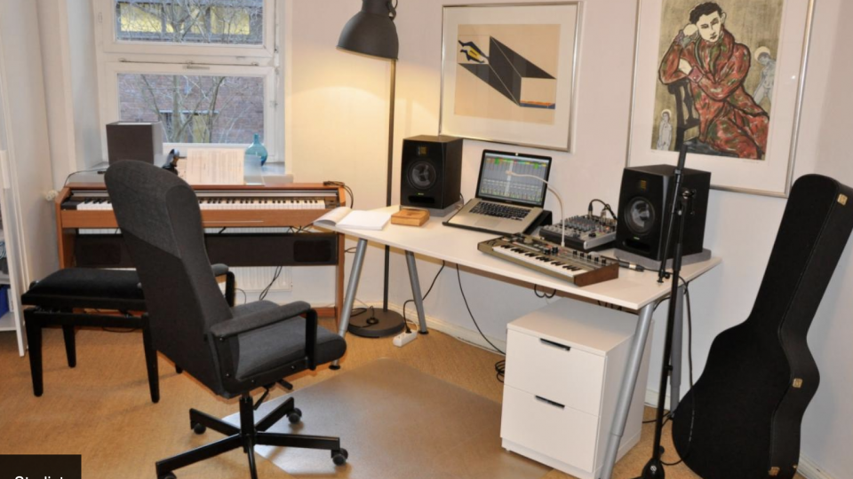 Et Berlin-optagestudie udstyret med et skrivebord, guitar og andet lydudstyr.