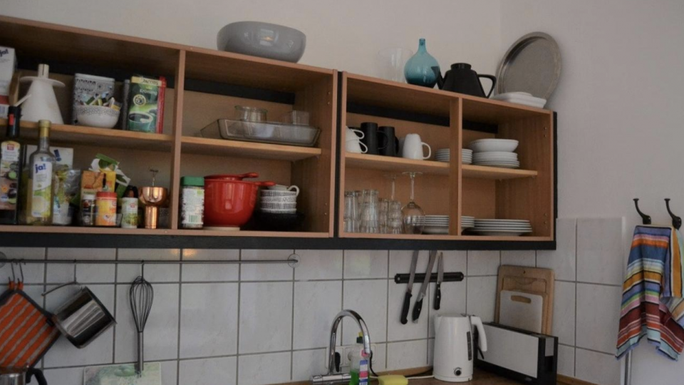 Et berlinsk køkken med vask og redskaber på en hylde.