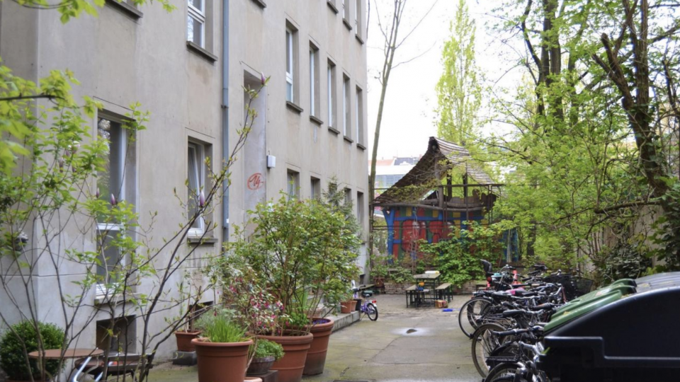 En gårdhave i Berlin med cykler parkeret foran en bygning.