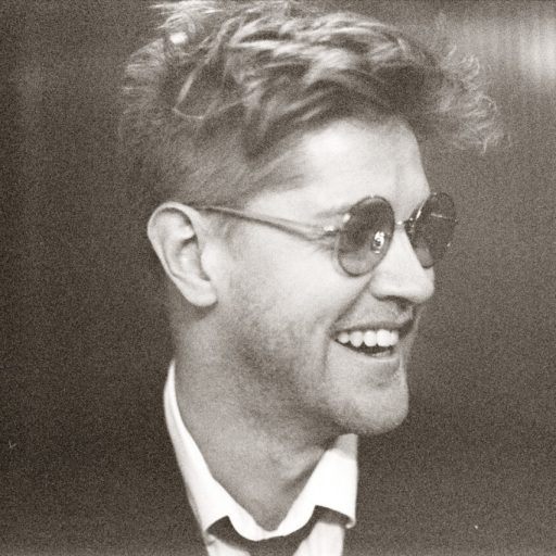Nikolaj Busk, en mand med solbriller, smiler.