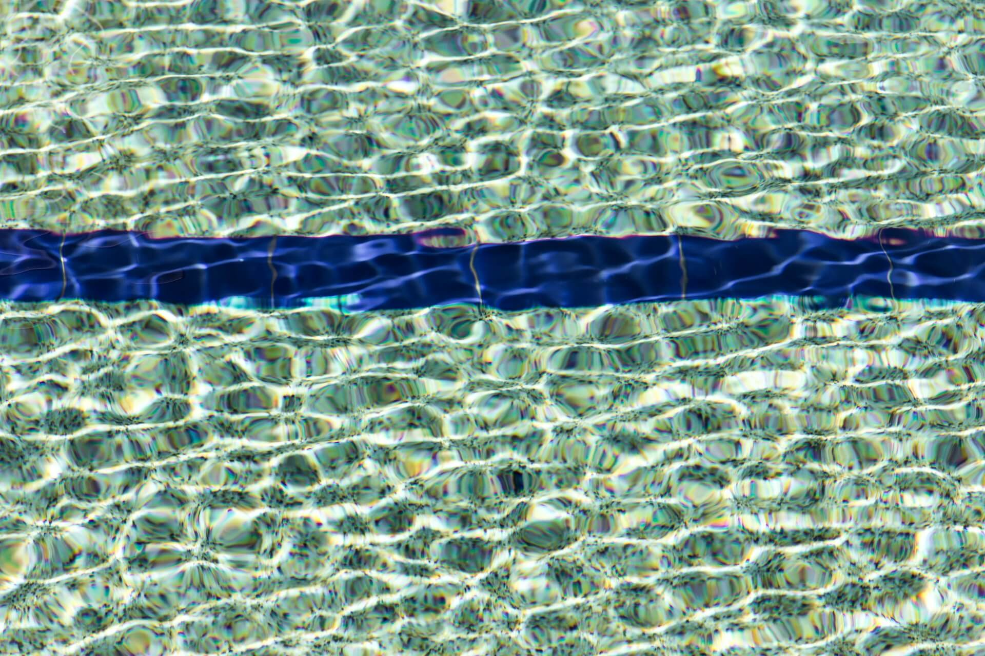 En blå streg i vandet i en svømmehal, der indikerer, at det er sommerlukket.