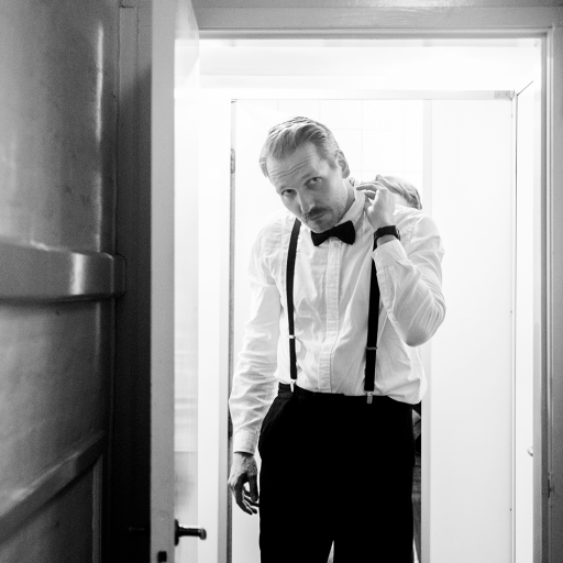 Mikkel Hess, en mand i smoking, der står i en døråbning.