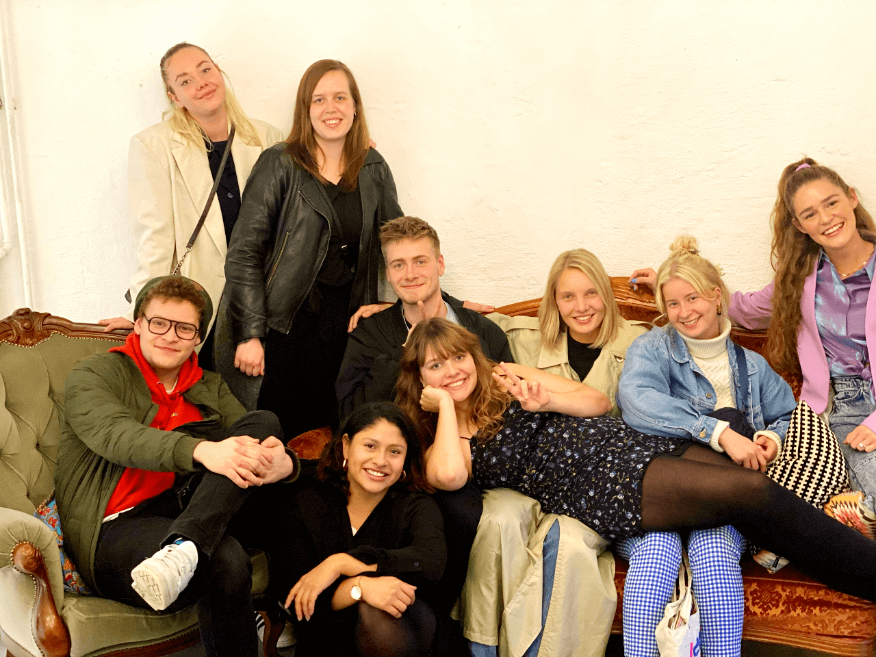 En gruppe mennesker poserer på en sofa i Stockholm 2021.