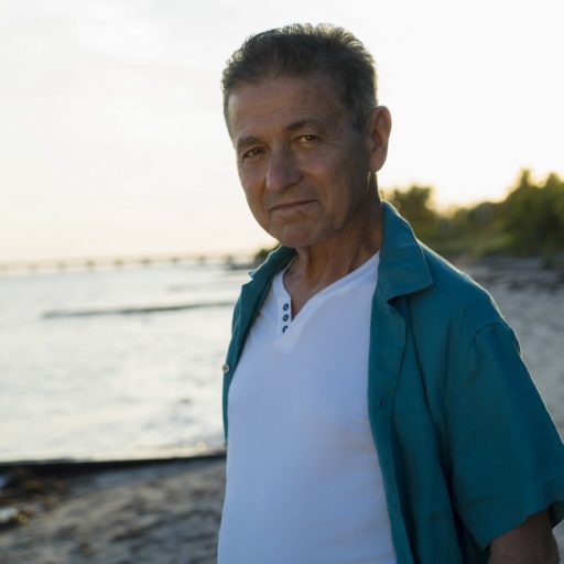 En mand ved navn Jorge Cordero, der står på en strand nær havet.