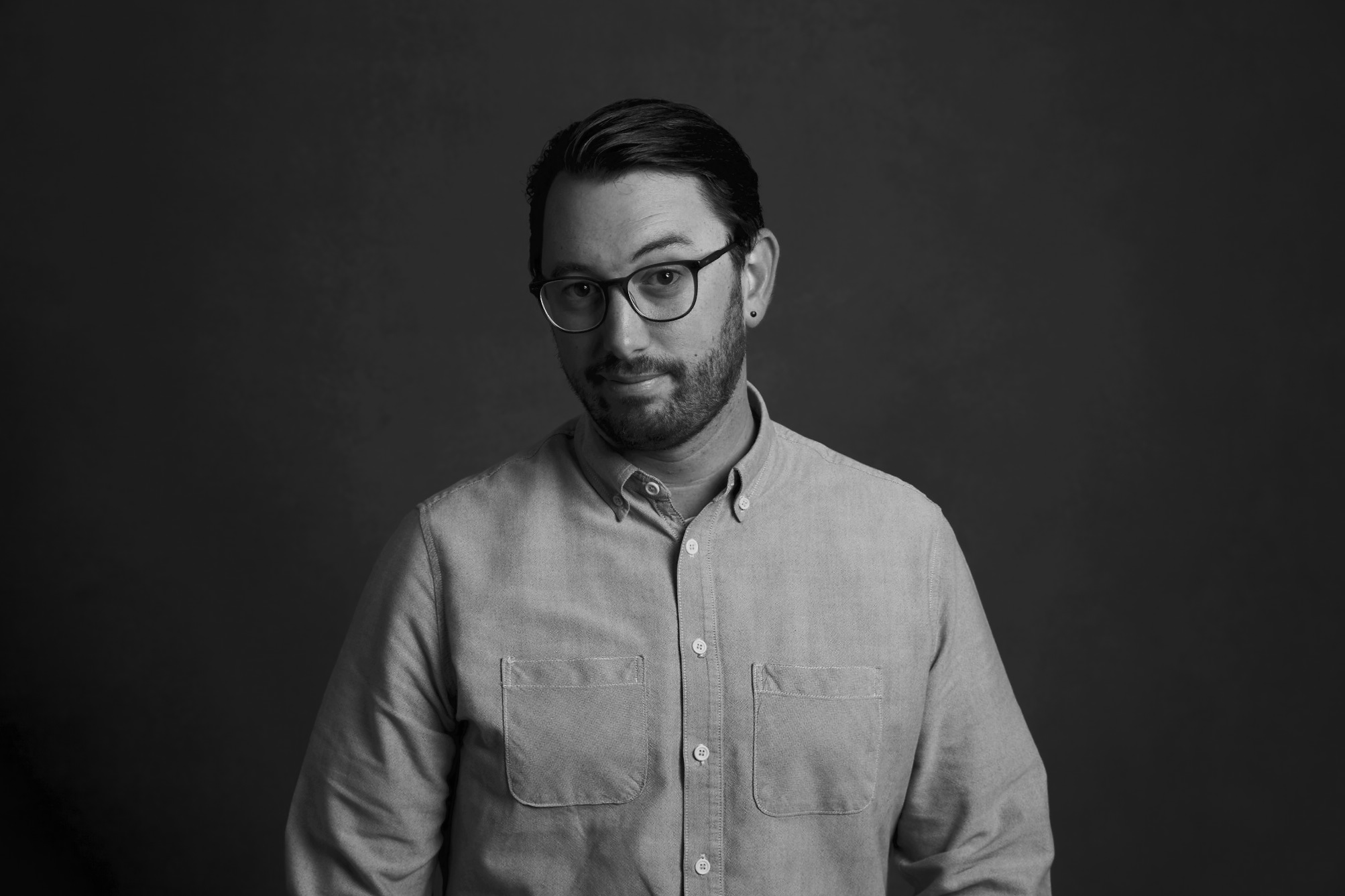 Et sort/hvidt foto af en mand iført briller, der viser sine digitale færdigheder.