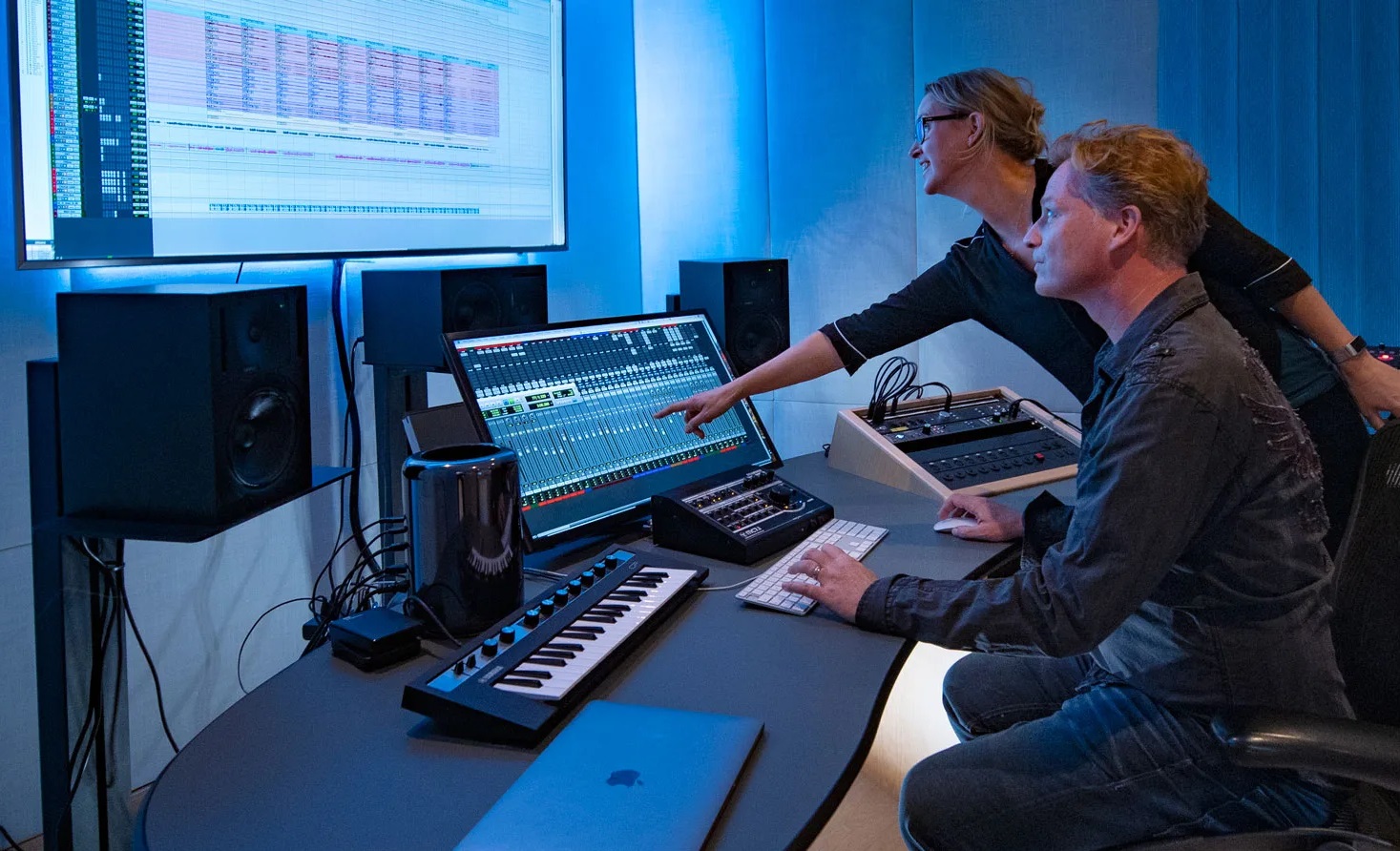 To personer på Palma Music Studios arbejder på en computer, mens de går i lydkurser.