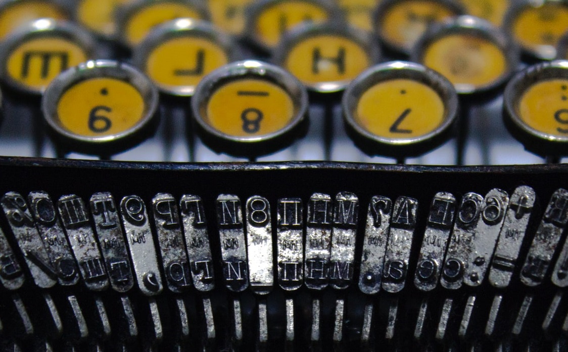 Et nærbillede af en gammel skrivemaskine, perfekt til en tekstgenerator.