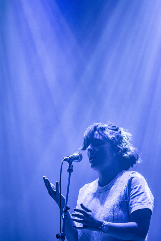 En kvinde synger i en mikrofon ved en Tekstgenerator-begivenhed i 2021.