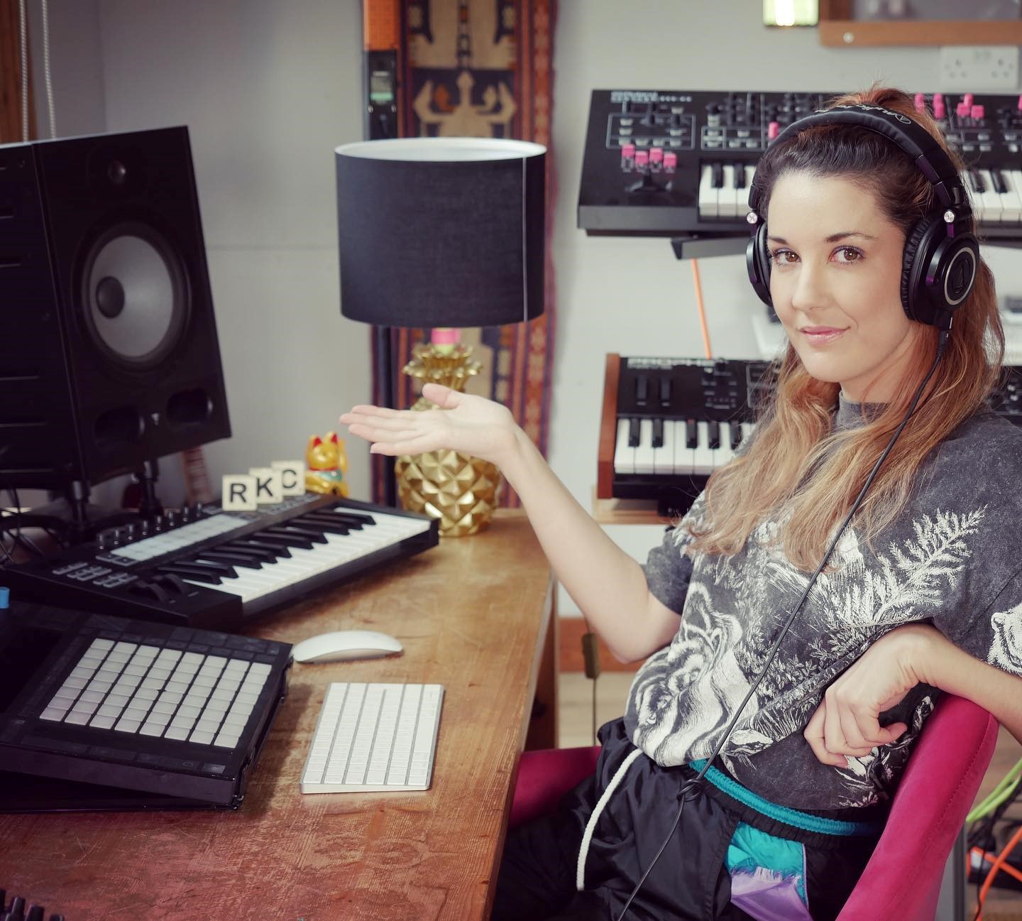 En kvinde, der sidder foran en computer med hovedtelefoner på, og laver musik ved hjælp af Ableton Live, mens hun følger vejledningsvideoer på YouTube fra Rachel K. Coller.
