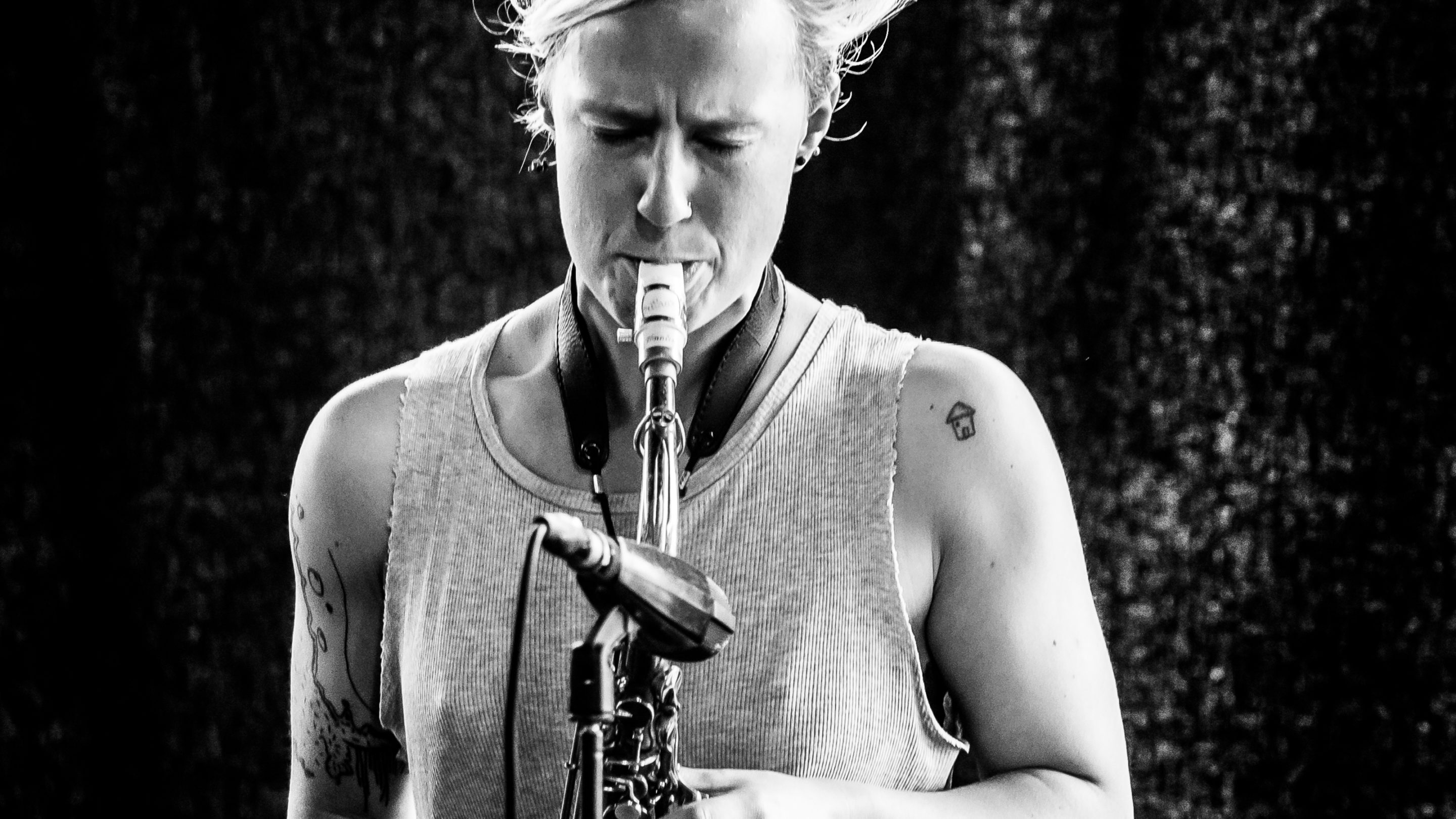 Et sort/hvid foto af Signe Emmeluth, der spiller saxofon.