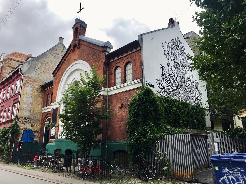 En kirke med cykler parkeret foran, fotograferet af Carl Bergstrøm-Nielsen.