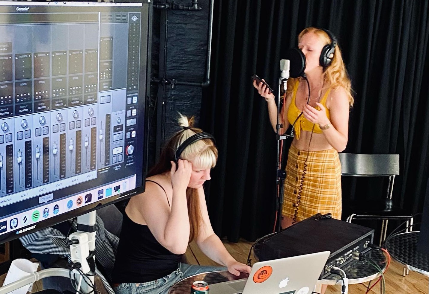 To kvinder i et optagestudie, der deltager i søndagsworkshops, med en eQ laptop foran sig.