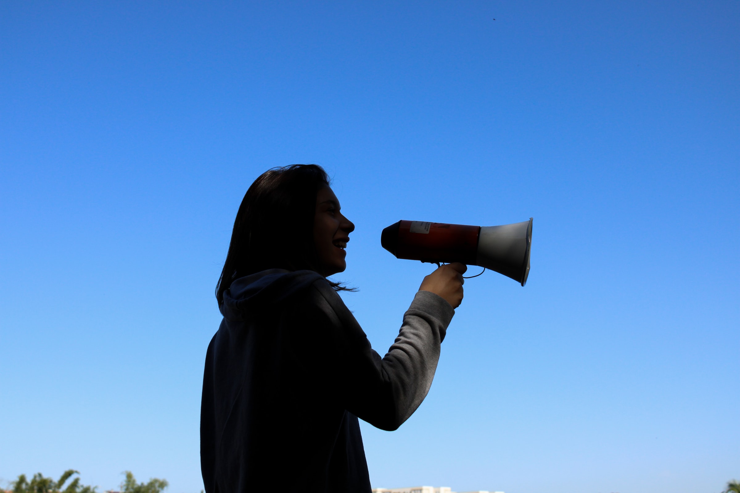 Online historiefortælling med en silhuet af en kvinde, der holder en megafon.