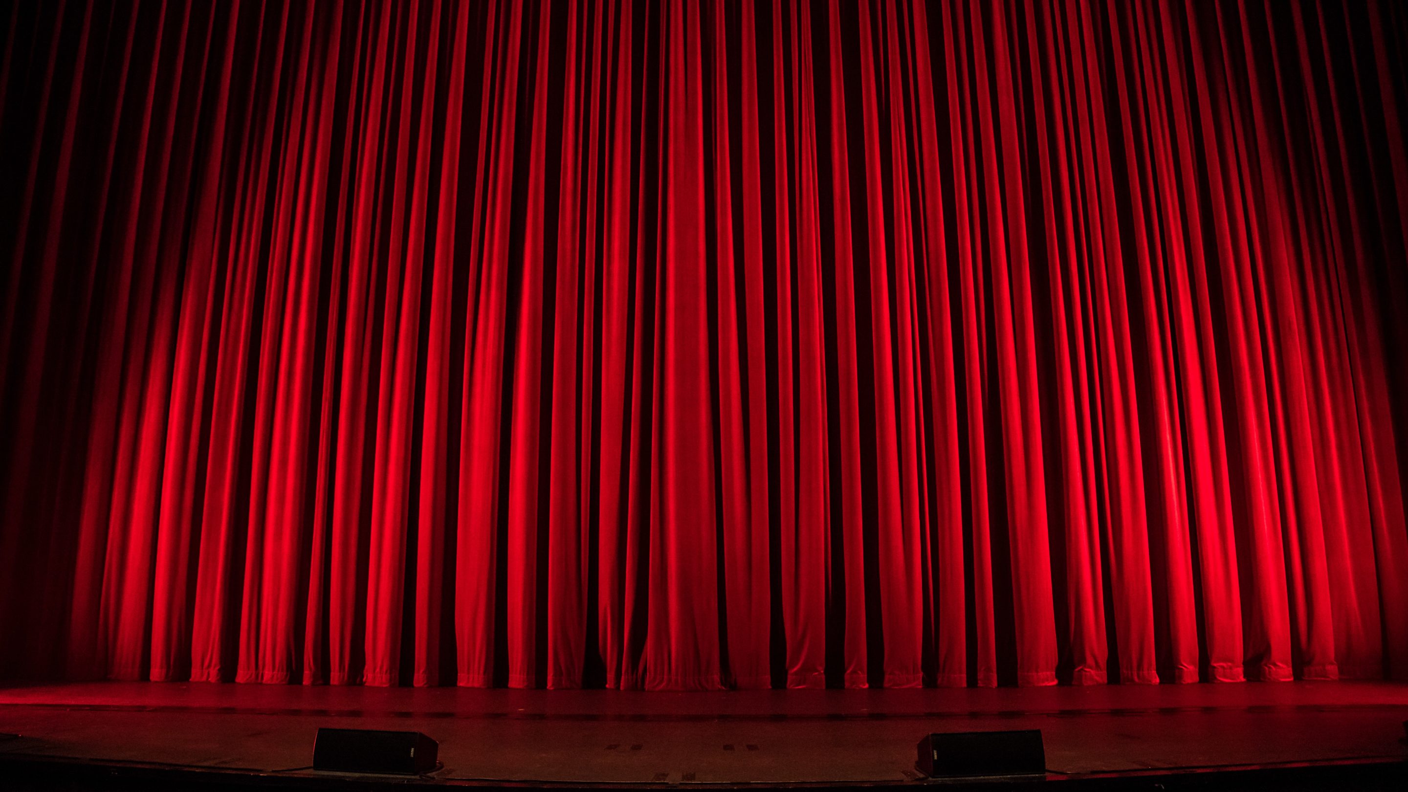 Et rødt gardin i et teater, der venter på at blive løftet til næste forestilling.