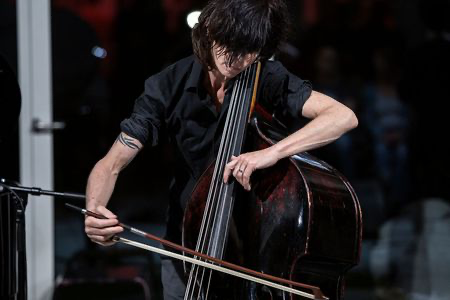 En mand, der spiller cello foran en entusiastisk skare.