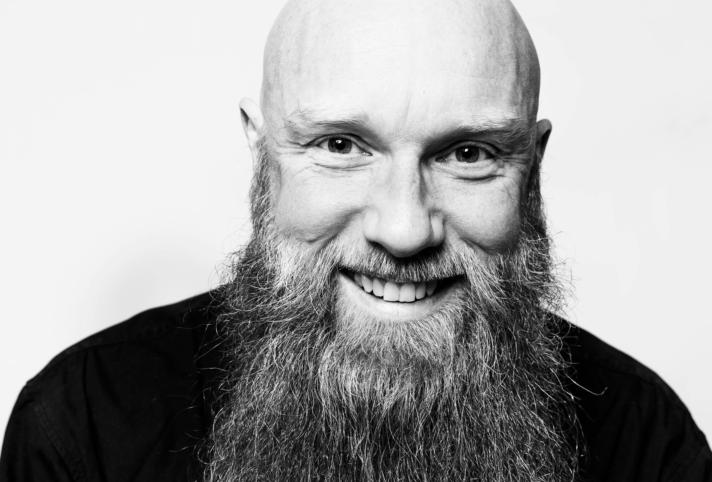 Et sort/hvidt foto af en skaldet mand med skæg, der viser skabertrang.