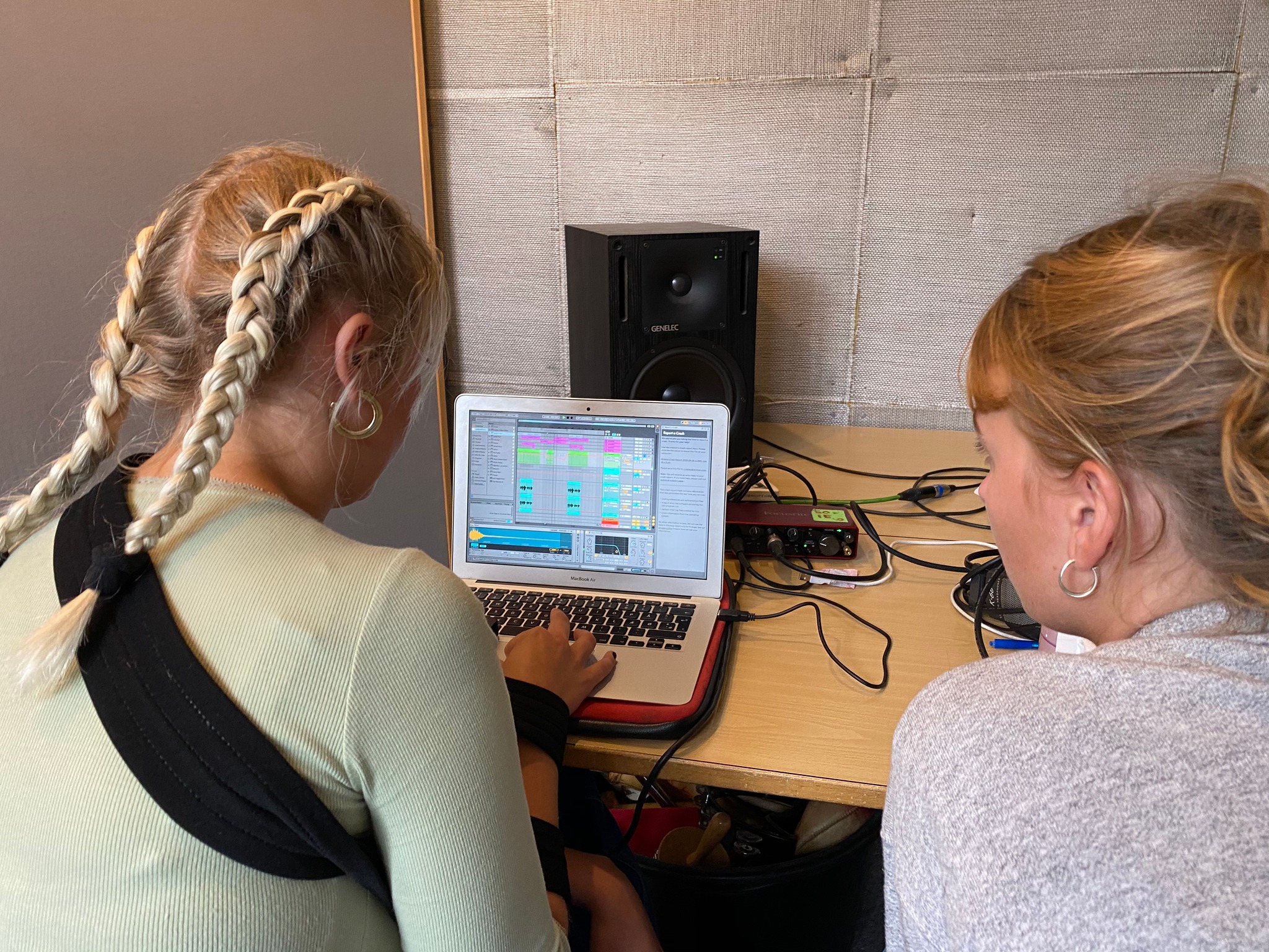 To kvinder, der deltager i en eQ Sundays workshop, arbejder flittigt på en bærbar computer i et værelse.