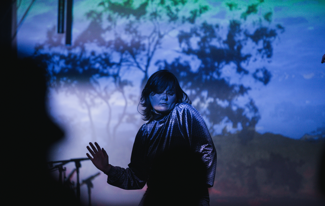 Katrine Stochholm optræder på scenen foran en blå skærm under Sangskriverværkstedet i Skabertrang Aarhus.