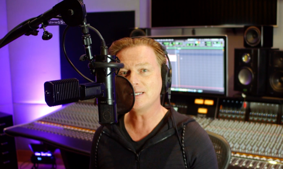 Fredrik Thomander foran en mikrofon under vokaloptagelse i et optagestudie.