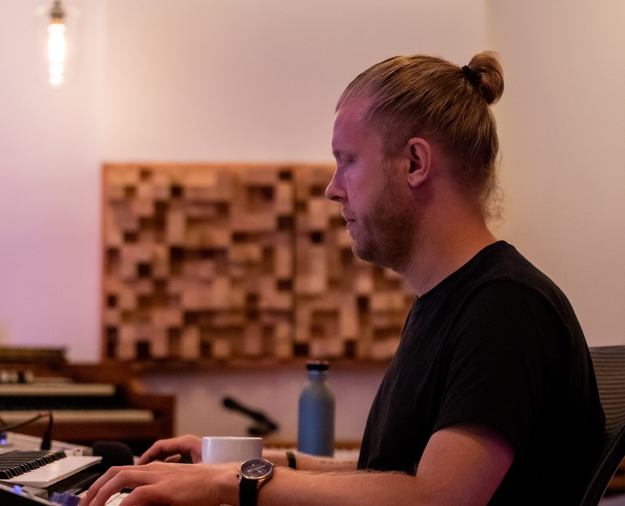En producer i Aarhus, drevet af Skabertrang, sidder ved et skrivebord med en bærbar computer foran sig.