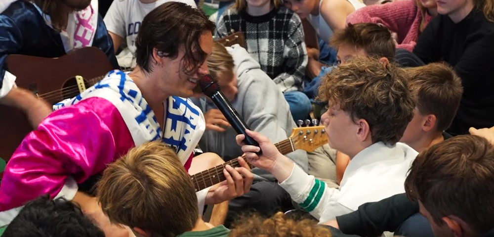 Levende Musik i Skolen - En mand, der spiller guitar foran en flok mennesker.