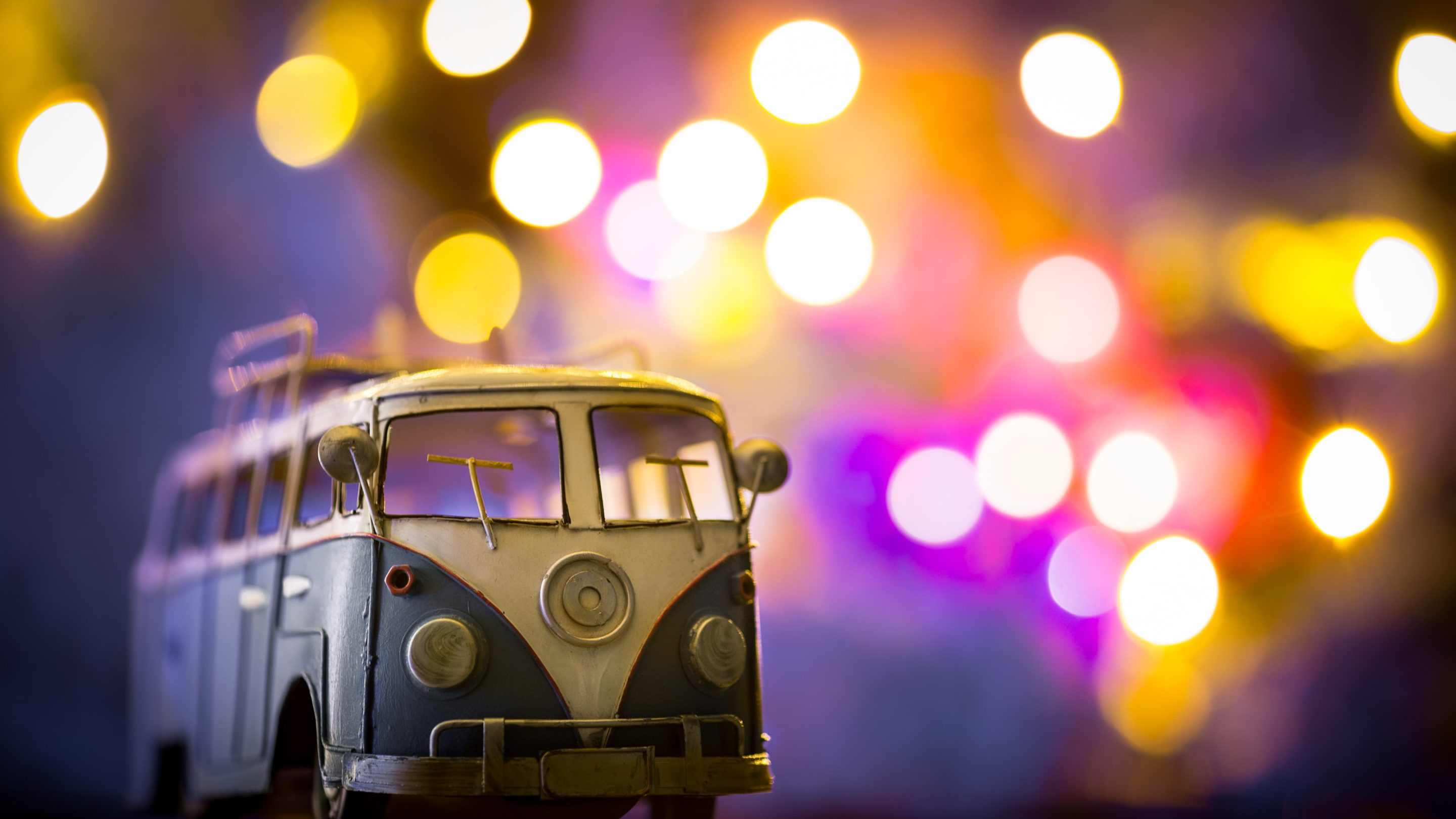 En legetøjs-vw-bus foran en bokeh-baggrund, der giver transportstøtte og emmer af Tempis-vibes.