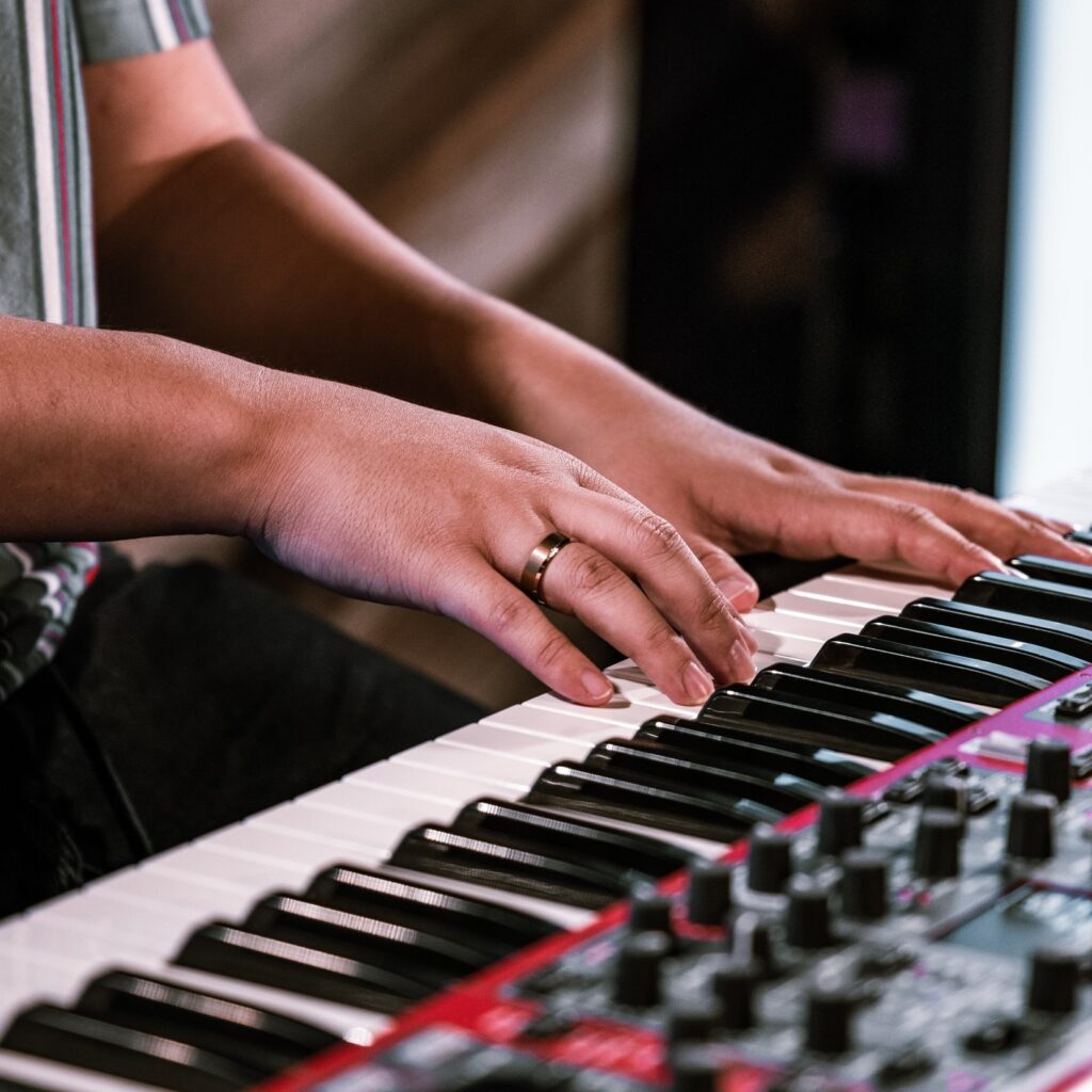 En persons hænder spiller dygtigt på et elektronisk keyboard for at skabe fascinerende melodier.