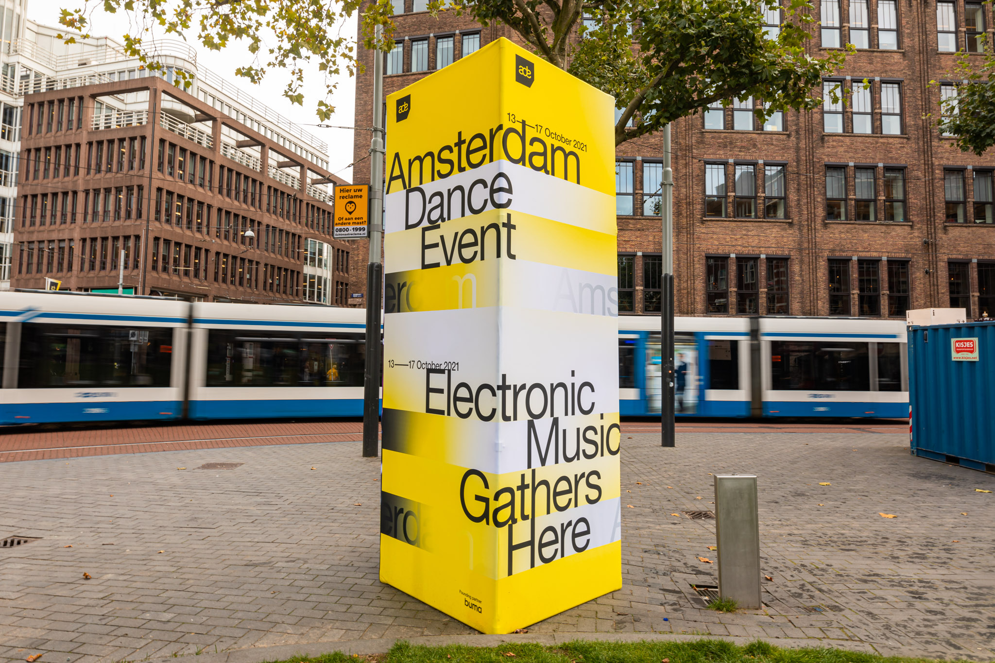 Et gult og sort skilt på en murstensvæg, der promoverer den kommende Electronic Fusion-begivenhed i Amsterdam 2023.