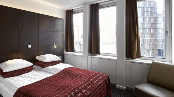 Et hotelværelse med to senge og et stort vindue, tilgængeligt med rabat for medlemmer.