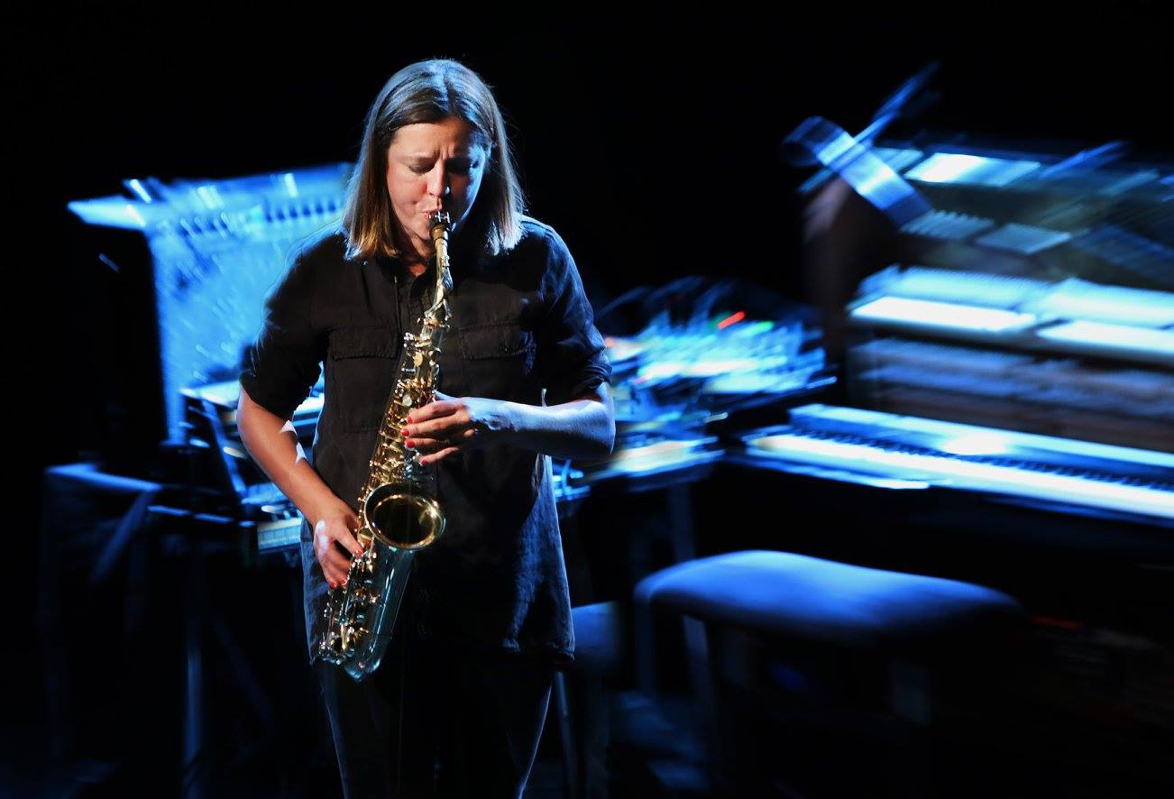 En kvinde, der spiller saxofon foran et klaver på Osgoods Netværk.