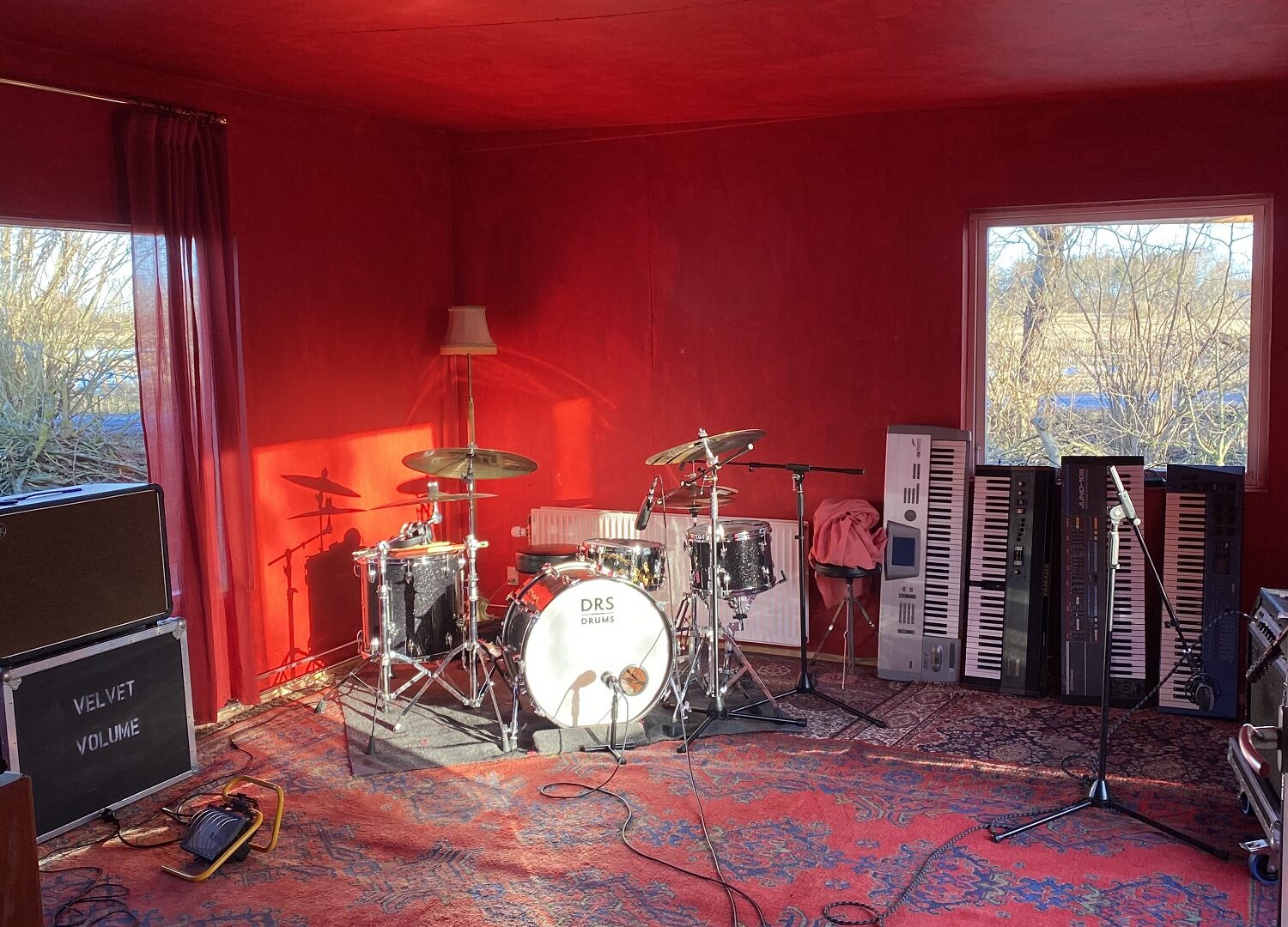 Et rum med røde vægge og et trommesæt, der inviterer dig ind i det rytmiske udforsknings kaninhul.