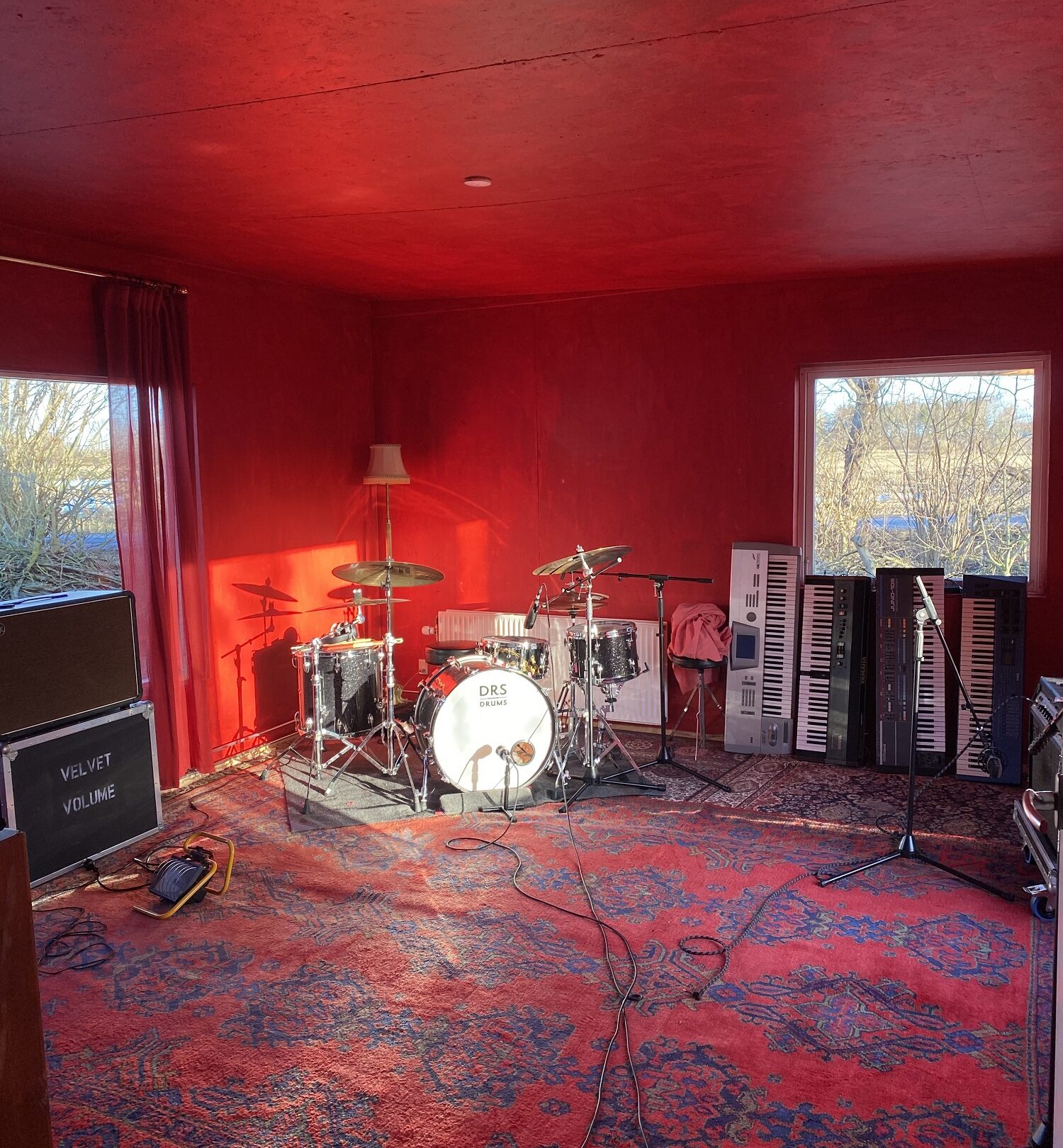 Et rum med røde vægge og et trommesæt, der inviterer dig ind i det rytmiske udforsknings kaninhul.