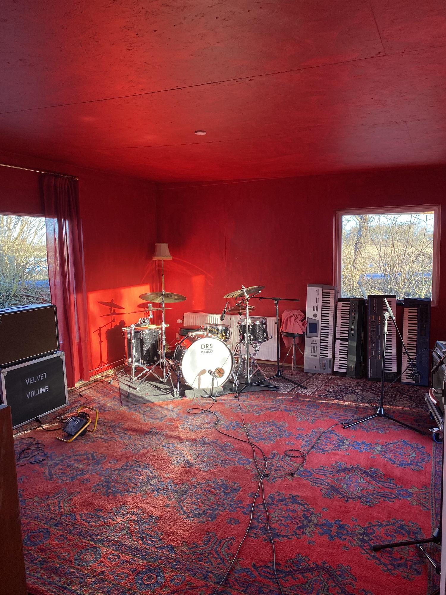 Et rum med røde vægge og et trommesæt, der inviterer dig ind i det rytmiske udforsknings kaninhul.