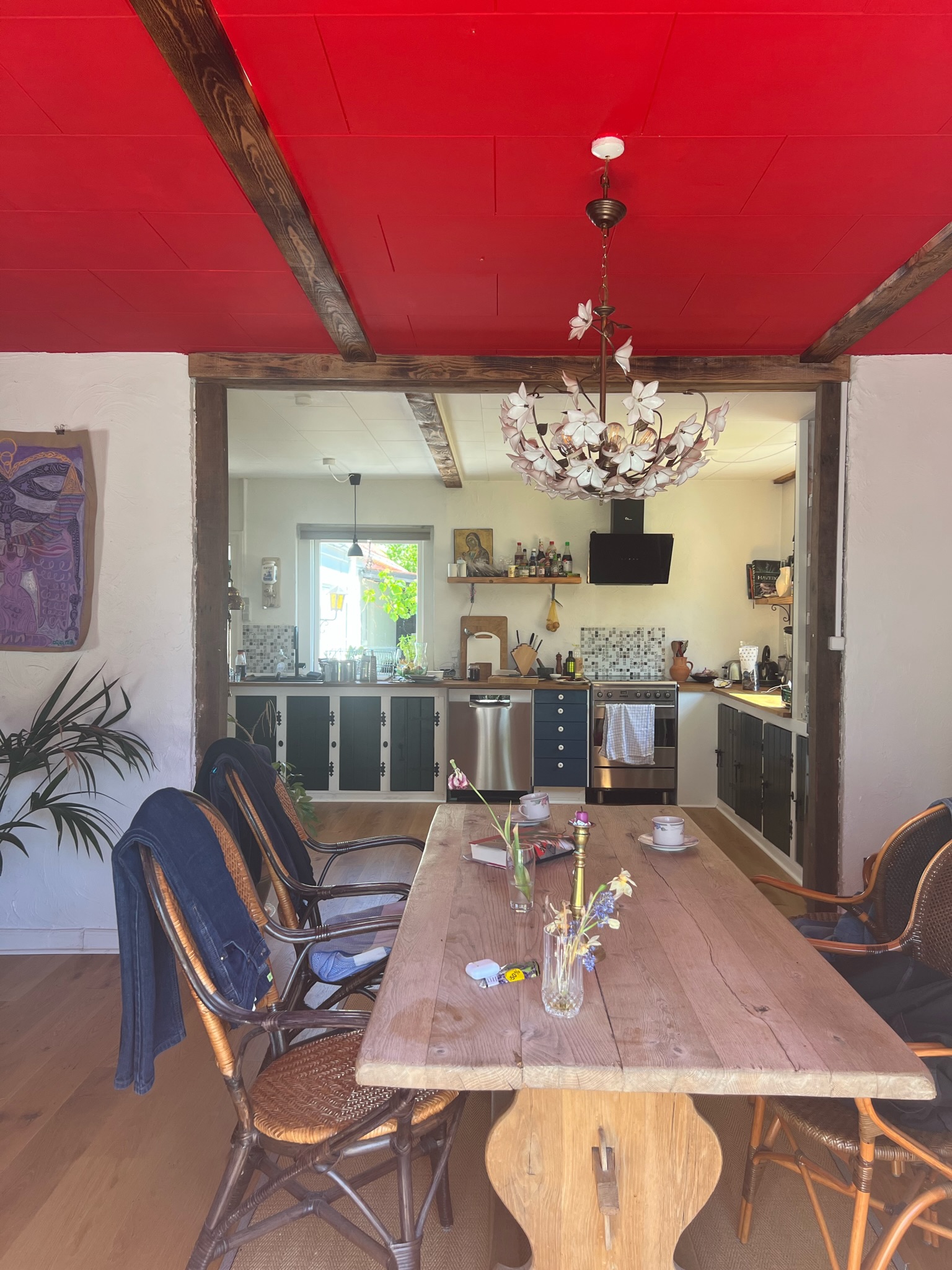Et køkken med rødt loft og et Kaninhullet træbord.