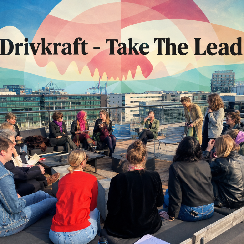 En gruppe mennesker sidder i en halvcirkel på en tagterrasse og lytter til en taler. I baggrunden ses byens bygninger og et vægmaleri med teksten »Drivkraft – Take The Lead«.